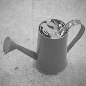 Watering can full of coins representing cash-flow