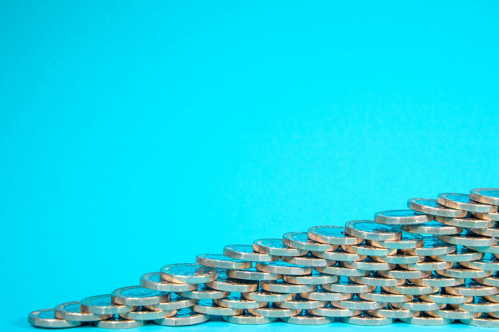 Pound Coins Stacked In Front Of Blue Background